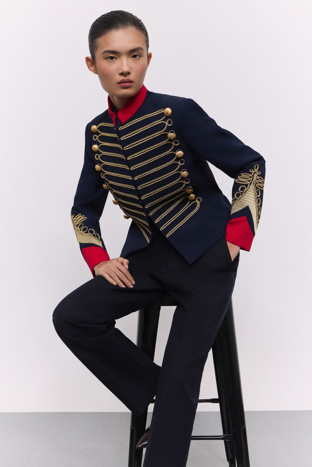Blazer azul marino con soutache Lancelot de The Extreme Collection con detalles de soutache dorado y puños rojos.