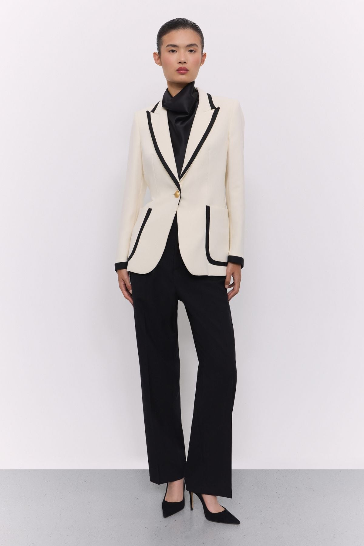 Blazer blanco con ribetes en contraste Laurent de The Extreme Collection en impecable blanco con vivos negros y sofisticados botones dorados.