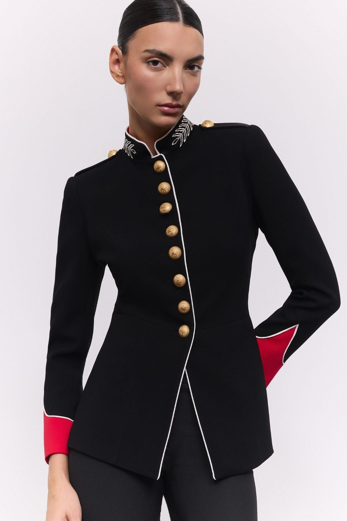 Blazer negra de estilo militar Dominique de The Extreme Collection con puños rojos y botones dorados.