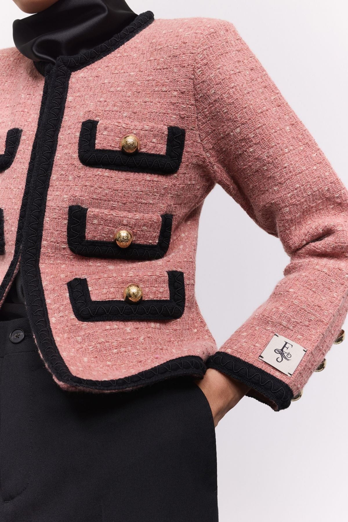 Chaqueta corta de punto rosa para mujer Preston, con ribetes negros en contraste y botones dorados.