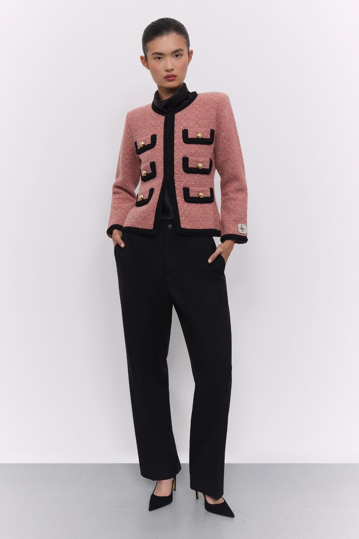 Chaqueta corta de punto rosa para mujer Preston, con ribetes negros en contraste y botones dorados.