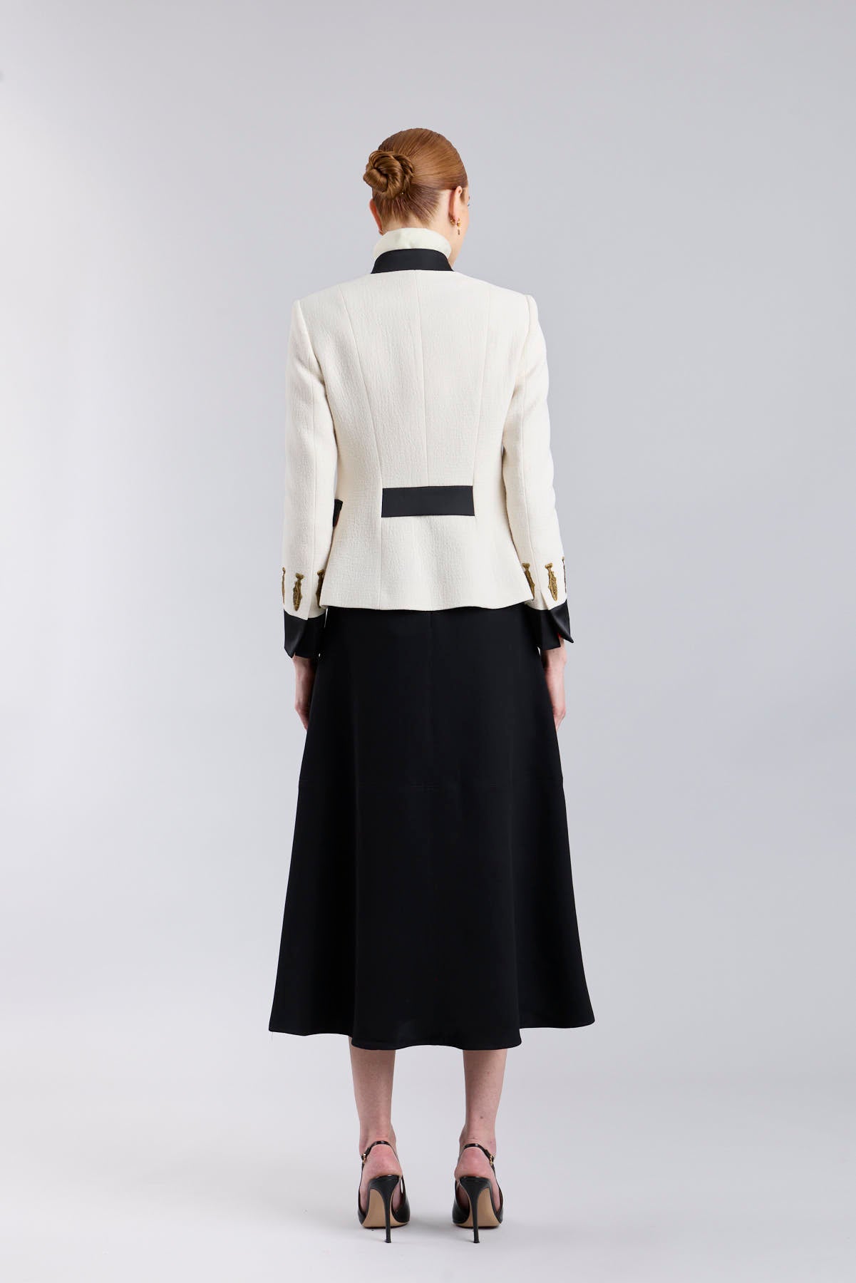 Falda midi de corte evasé color negro con detalle de hebillas en la cintura de The Extreme Collection.