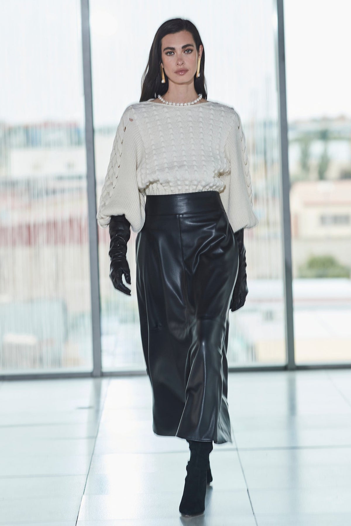 Falda midi ecopiel negra de cintura alta con efecto piel y un cautivador tono profundo. Elegancia, audacia y versatilidad.