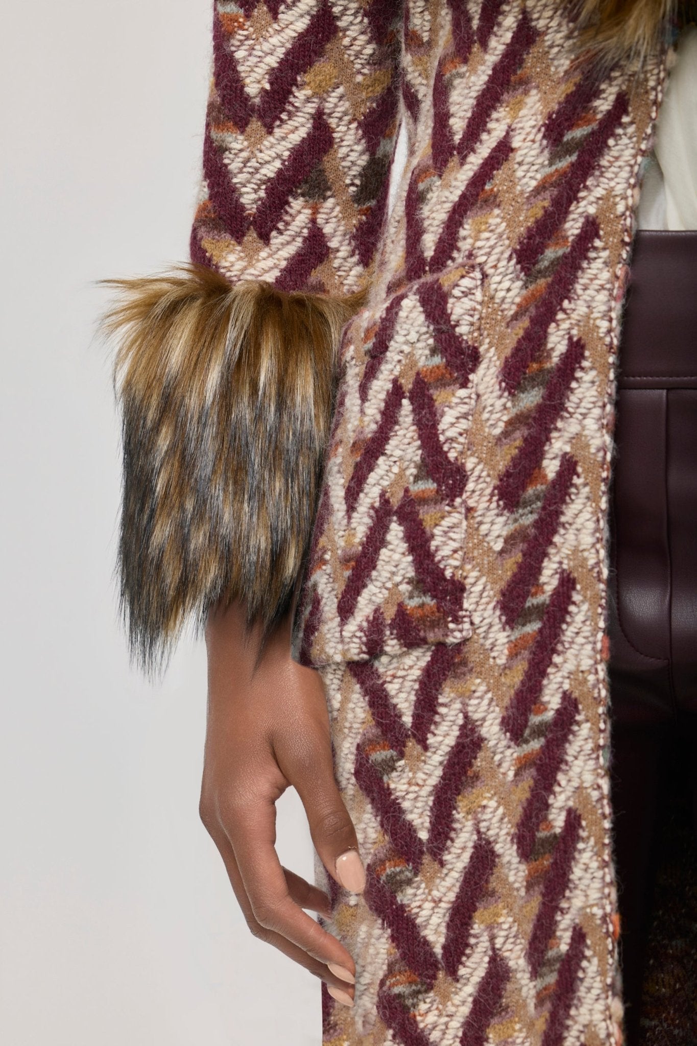 Abrigo de punto con pelo modelo Flavia, con base de tejido geométrico y aplicaciones de pelo en cuello y puños.