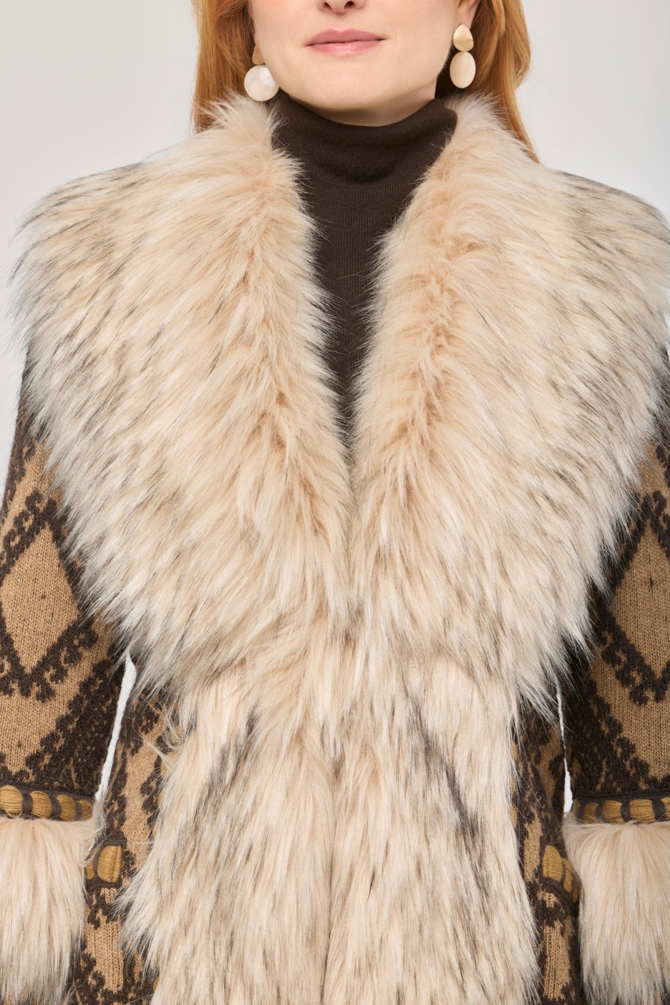 Abrigo largo de punto con pelo Kira, combinando una base de jacquard geométrico en tonos tierra con aplicaciones de pelo en cuello y puños.