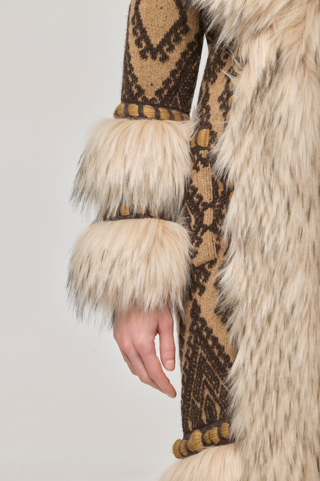 Abrigo largo de punto con pelo Kira, combinando una base de jacquard geométrico en tonos tierra con aplicaciones de pelo en cuello y puños.