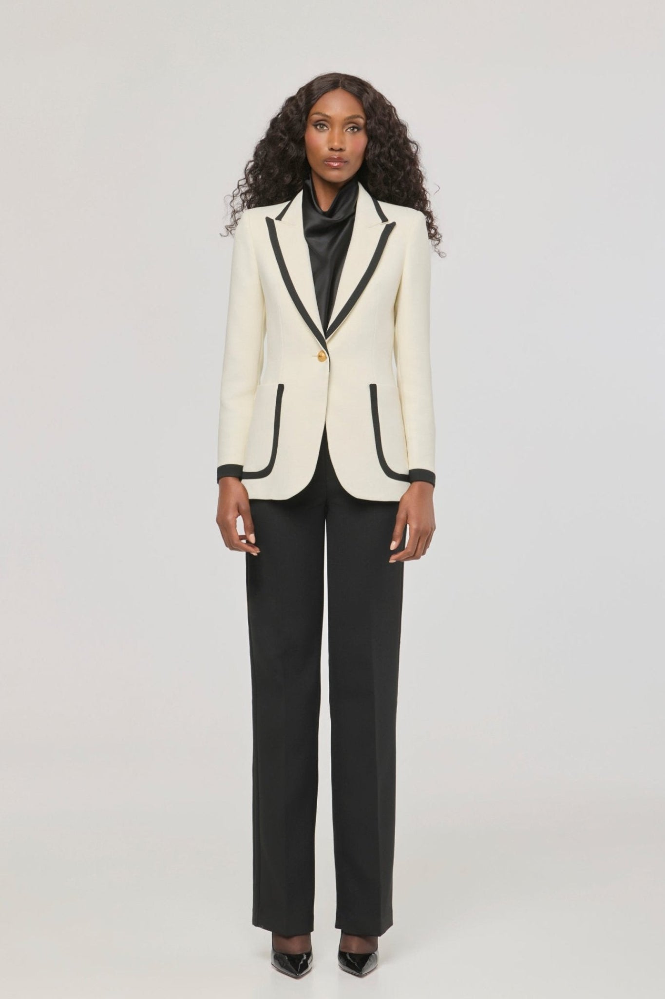 Blazer blanco con ribetes en contraste Laurent de The Extreme Collection en impecable blanco con vivos negros y sofisticados botones dorados.