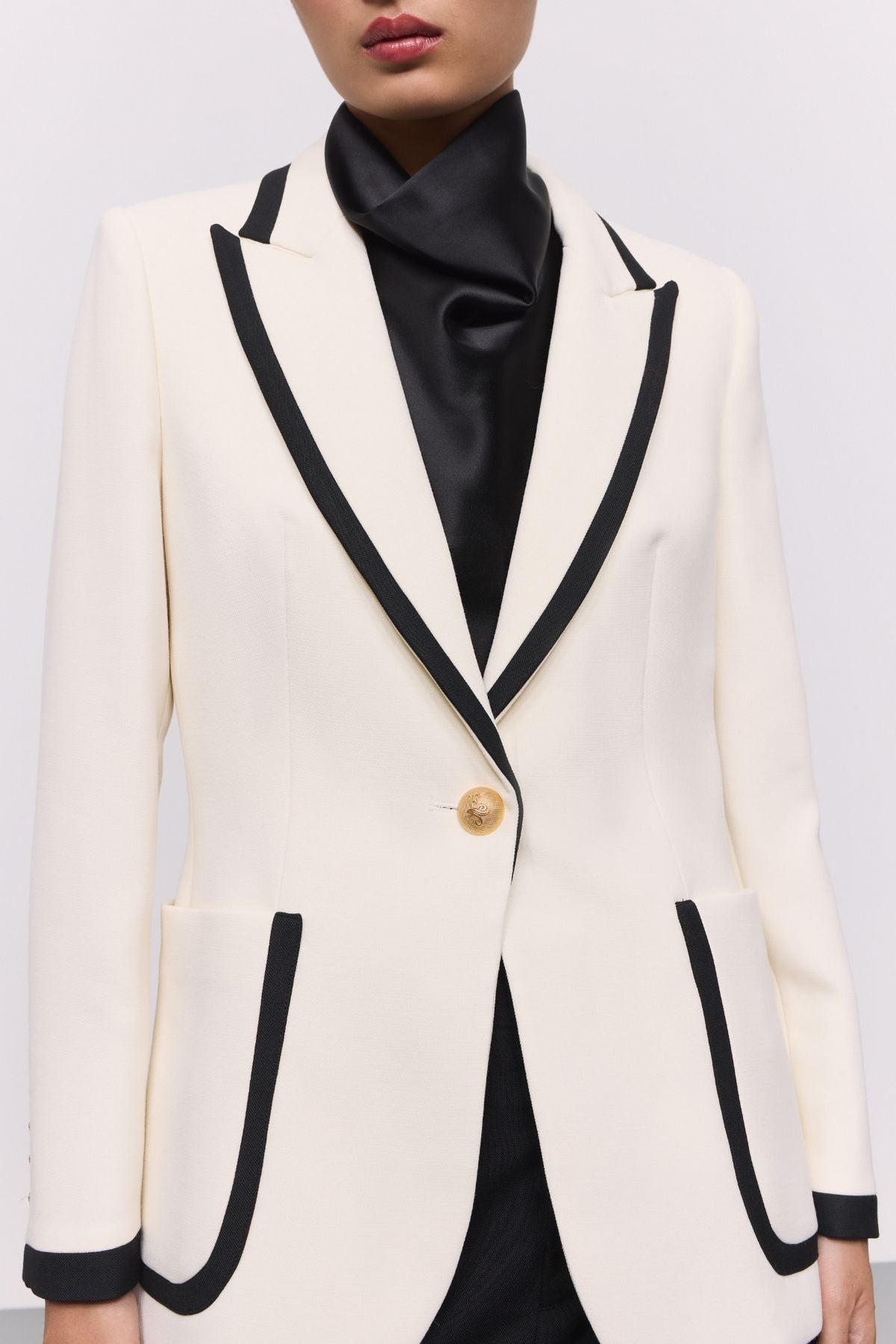 Blazer blanco con ribetes en contraste Laurent de The Extreme Collection en impecable blanco con vivos negros y sofisticados botones dorados.