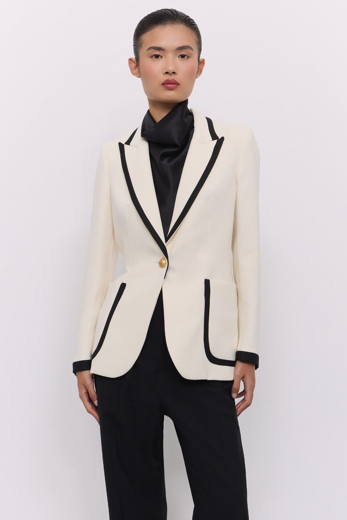Blazer blanco con ribetes en contraste Laurent de The Extreme Collection en impecable blanco con vivos negros y sofisticados botones dorados.