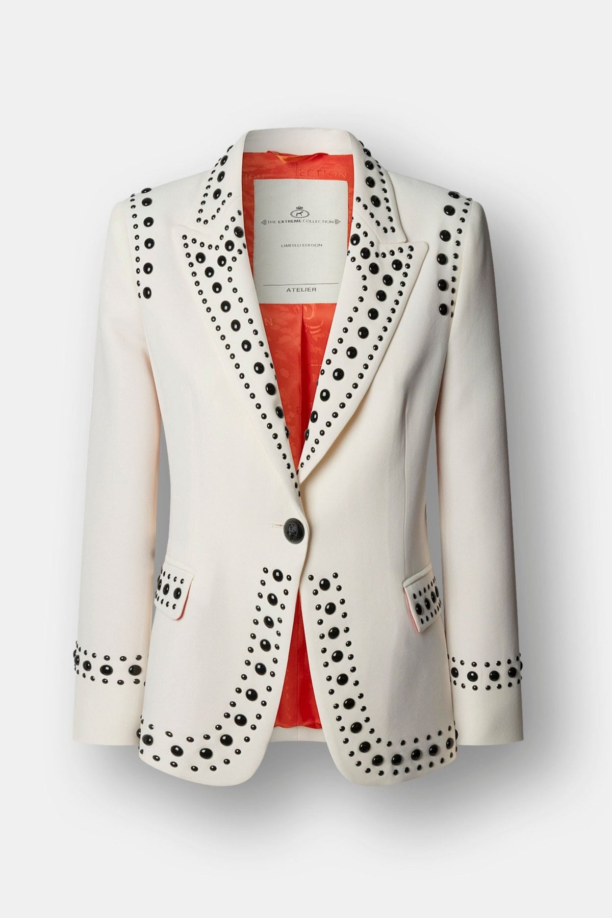 Blazer blanco roto con tachuelas Rock Star entallada con solapa de punta de lanza y tachas negras de alto brillo. Sastrería artesanal hecha en España.