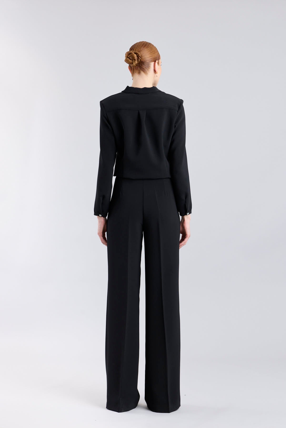 Blusa negra con cuello tipo esmoquin de The Extreme Collection.