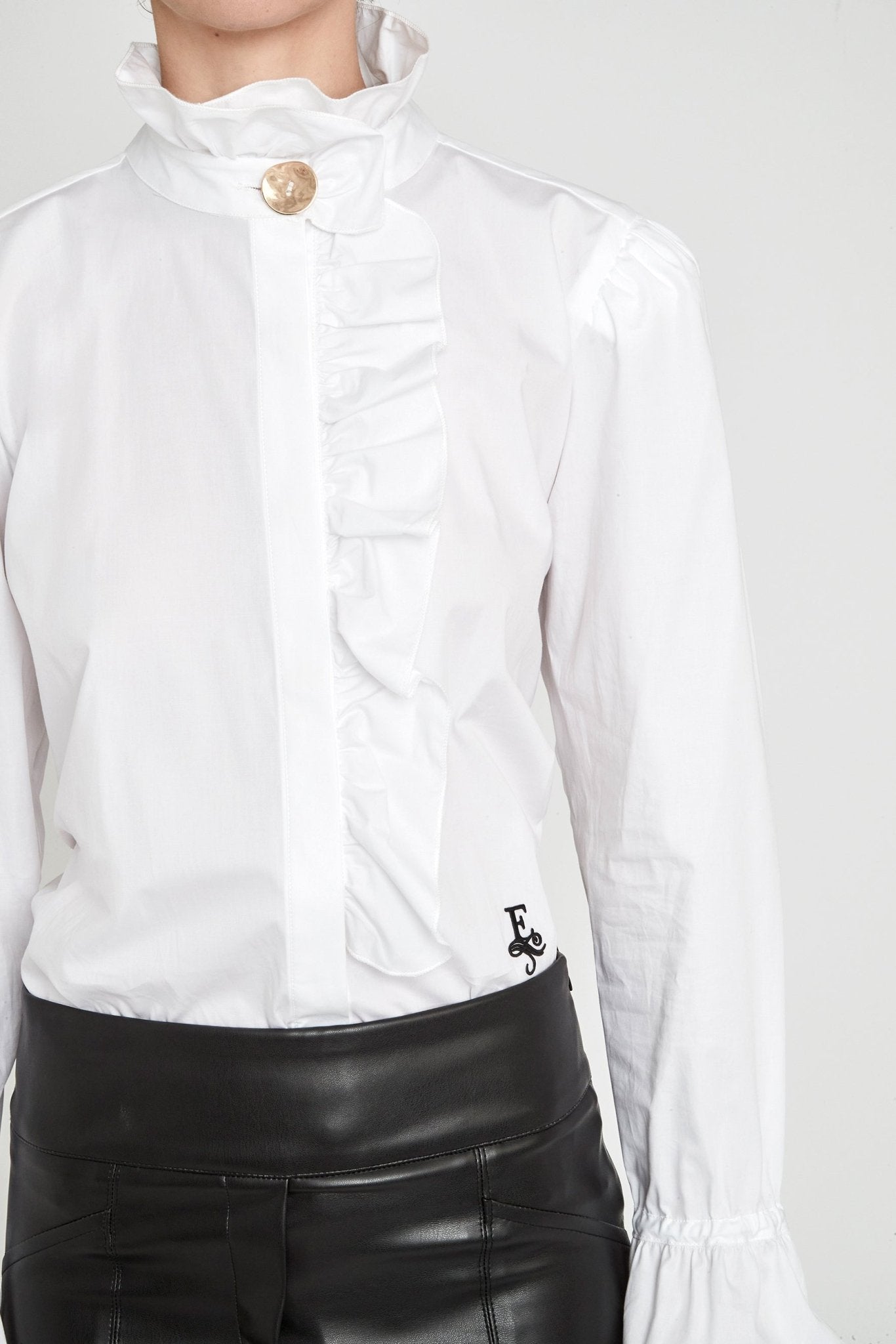 Camisa blanca con volante Boheme de The Extreme Collection en color blanco con elegante volante frontal, cuello alto y puños acampanados.