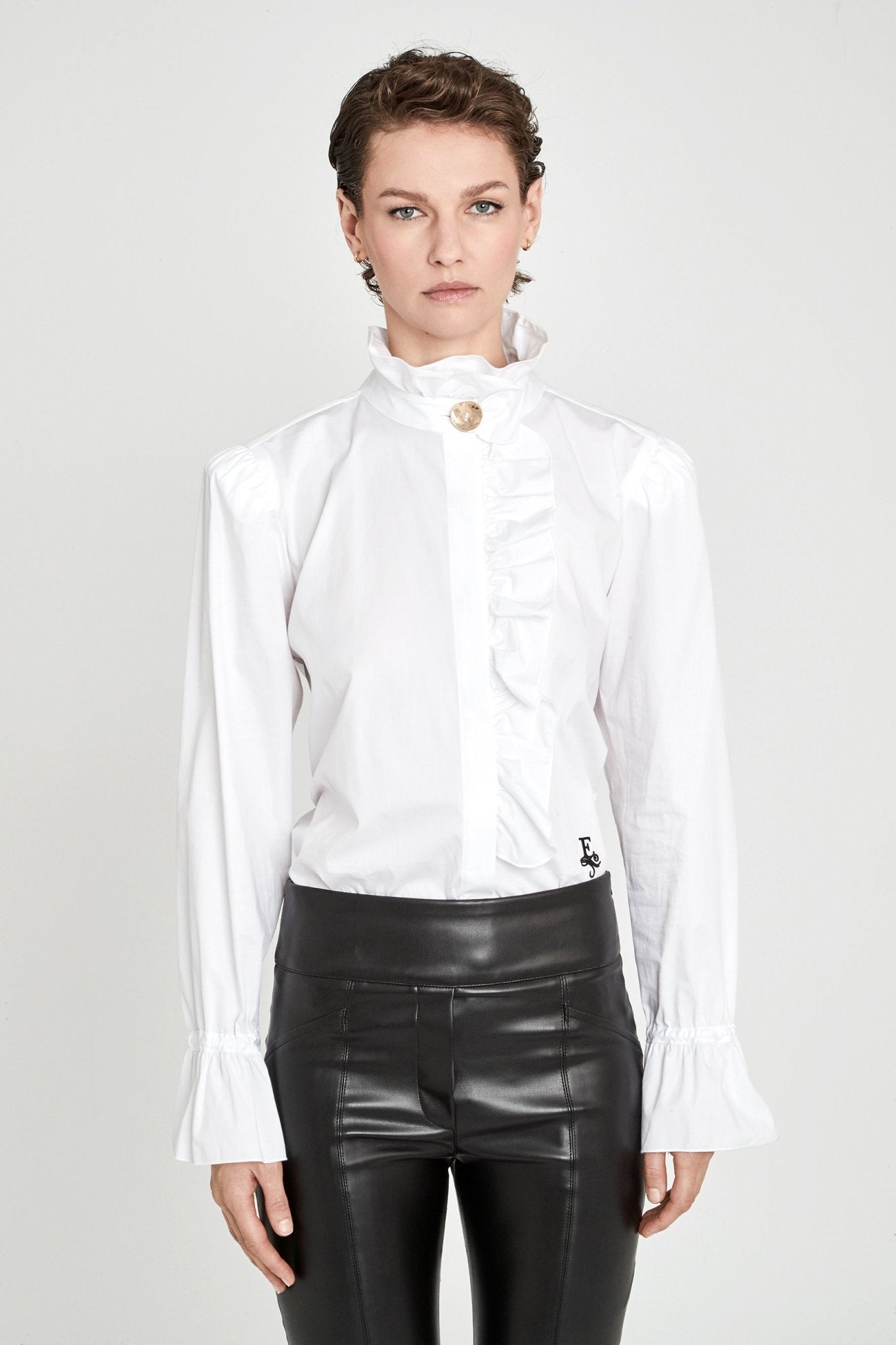 Camisa blanca con volante Boheme de The Extreme Collection en color blanco con elegante volante frontal, cuello alto y puños acampanados.