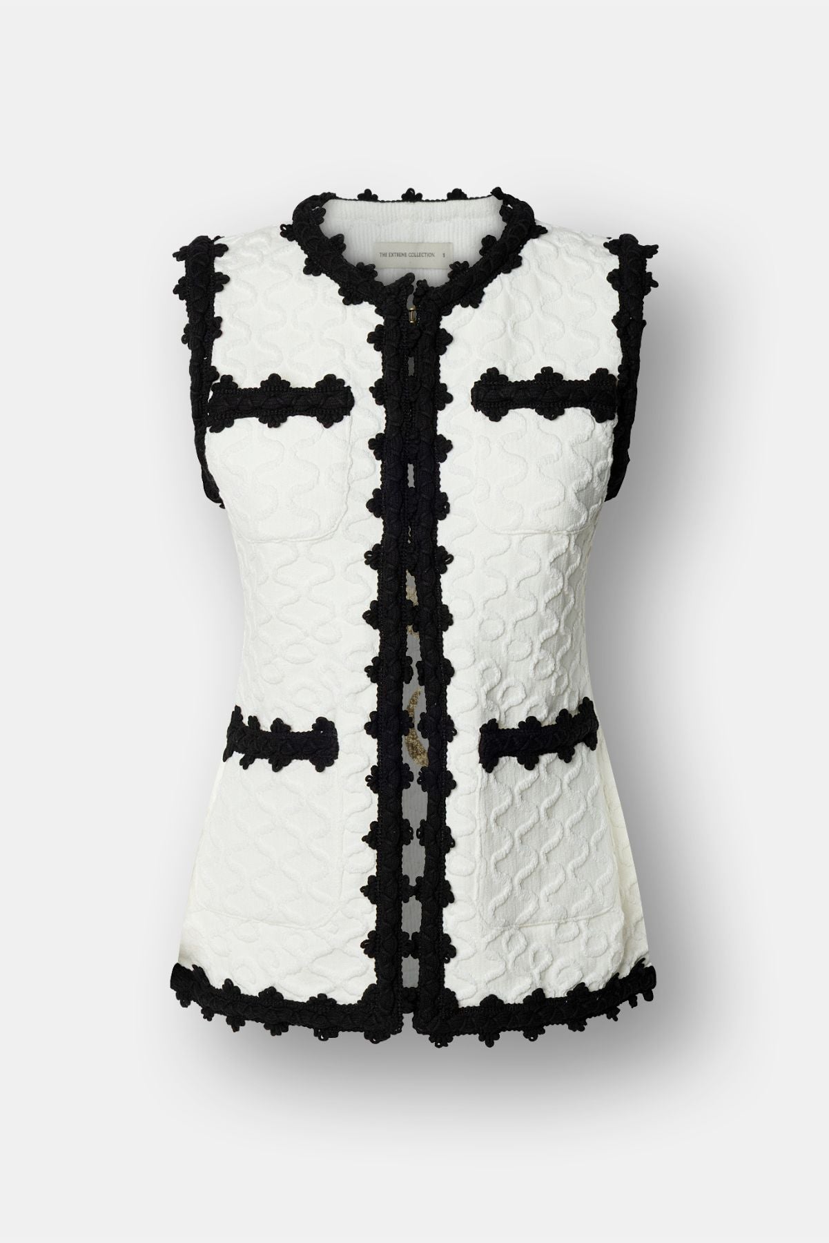 Chaleco de lujo blanco para mujer modelo Tristan con perfiles festoneados en negro.