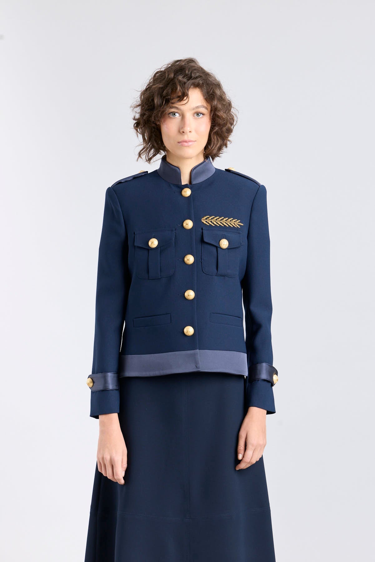 Chaqueta militar azul marino Ilva Star con bordados frontales en hilo dorado.