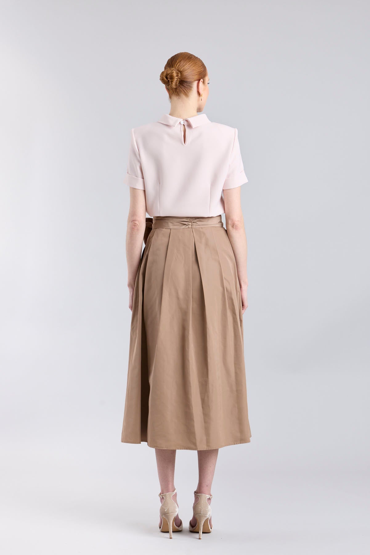 Falda midi color camel con volumen y detalle de lazo en la cintura de The Extreme Collection.