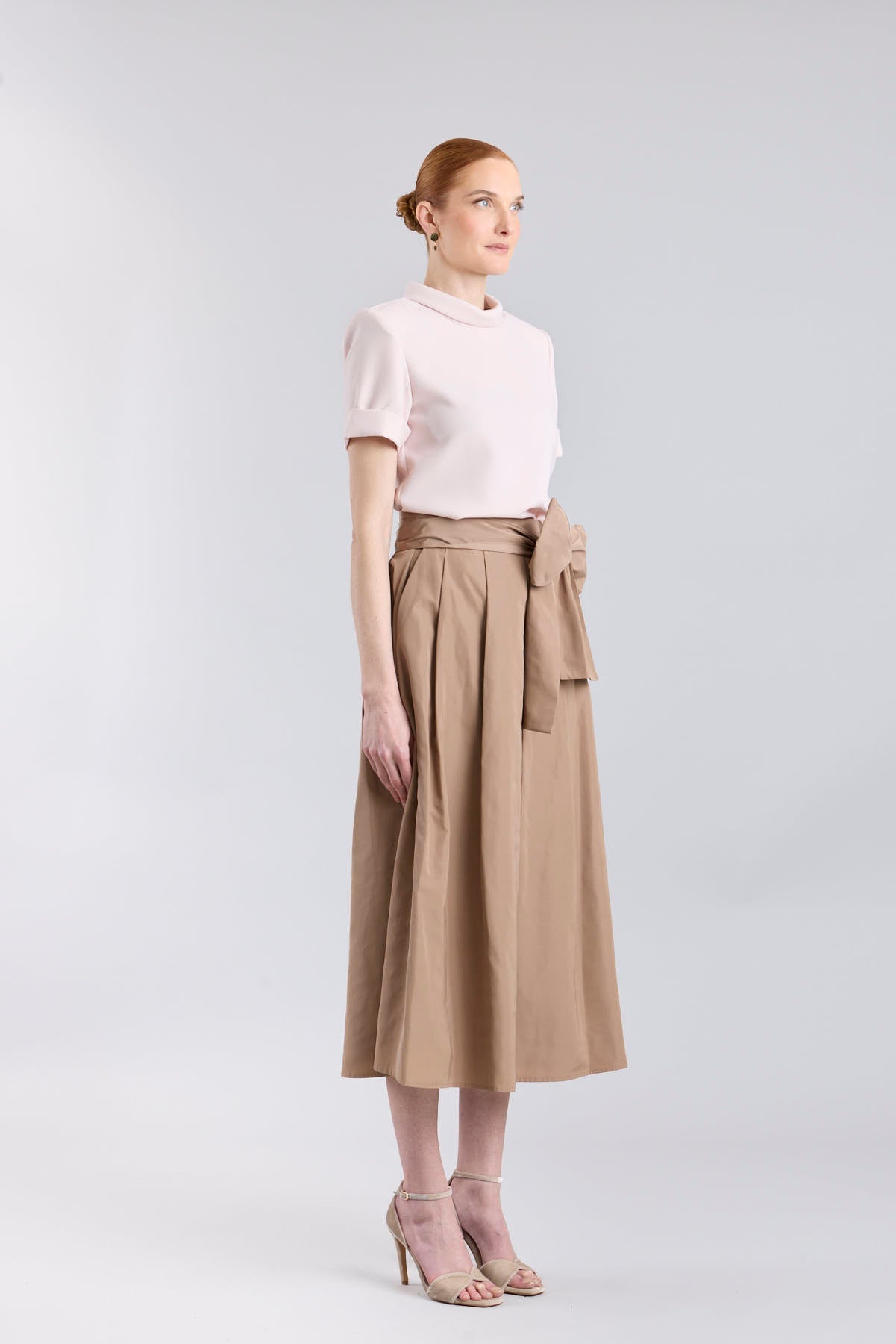 Falda midi color camel con volumen y detalle de lazo en la cintura de The Extreme Collection.