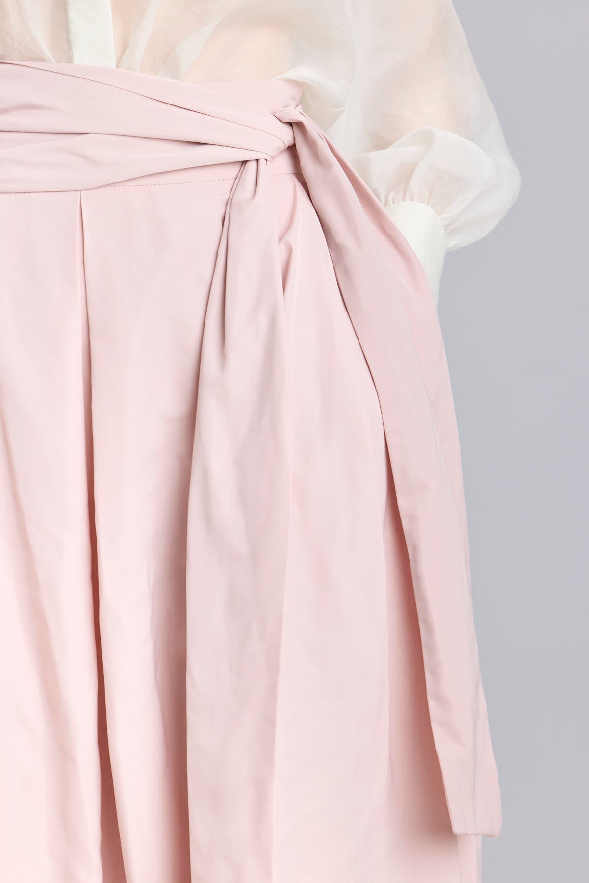 Falda midi rosa empolvado con volumen y lazo en la cintura de The Extreme Collection.