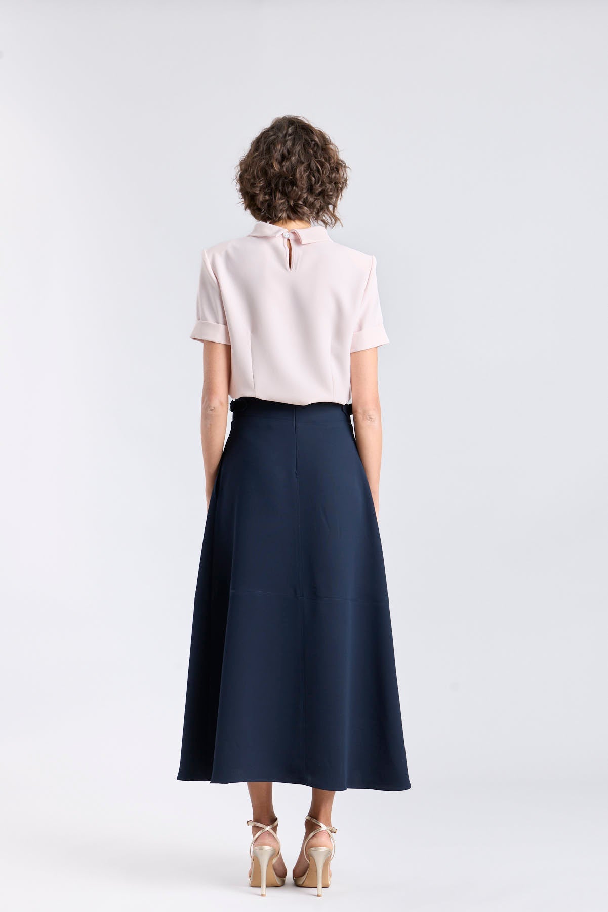 Falda midi de corte evasé color azul marino con detalle de hebillas en la cintura de The Extreme Collection.